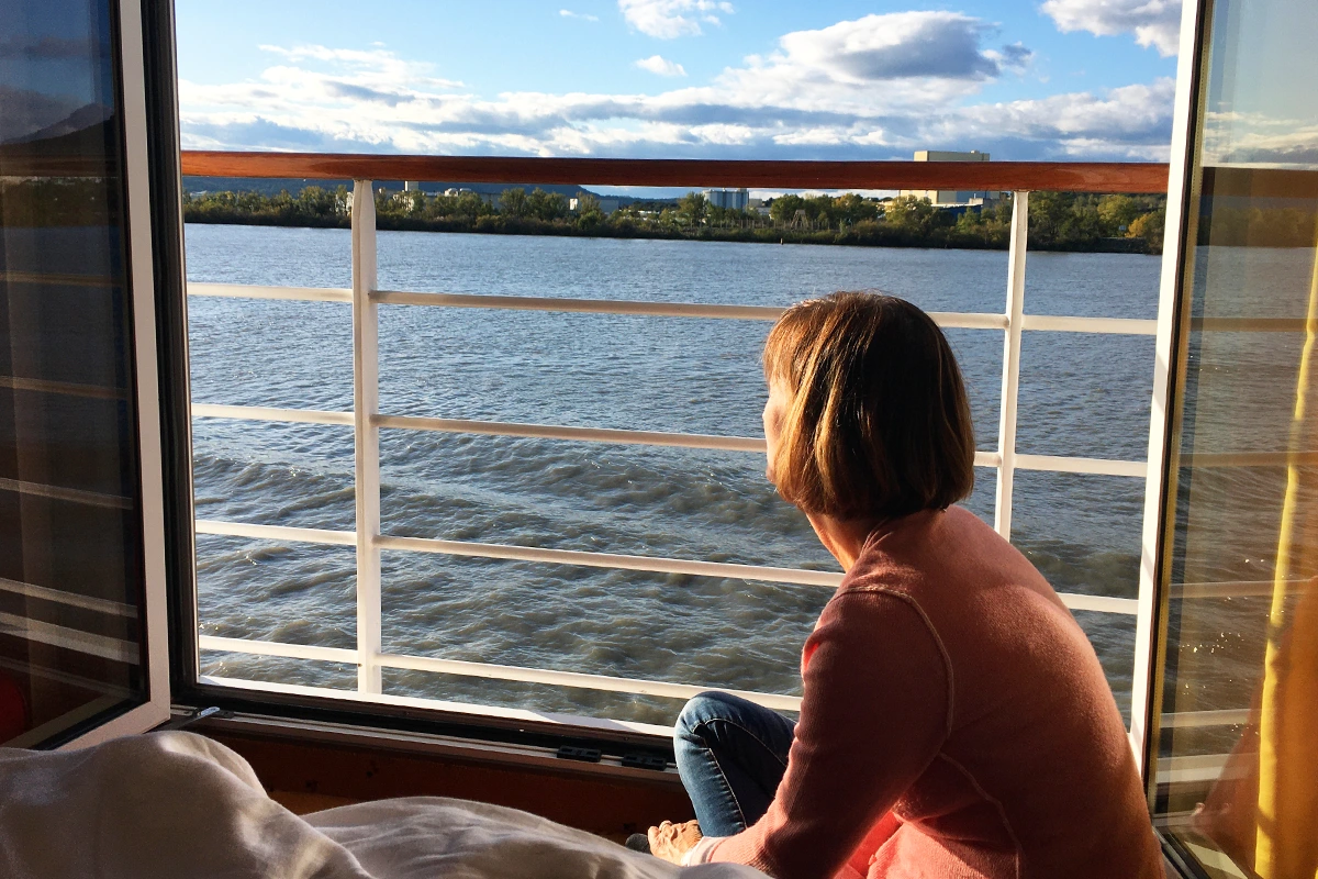 Flusskreuzfahrt mit A-ROSAauf der Rhone, Tina Vogt sitzt am Fenster und genießt die Aussicht auf das Wasser