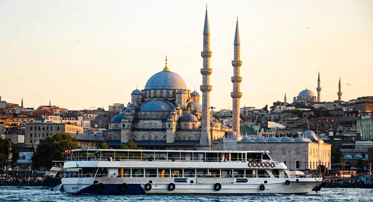 Eine Schifffahrt über den Bosporus in Istanbul mit einer großen Moschee im Hintergrund.