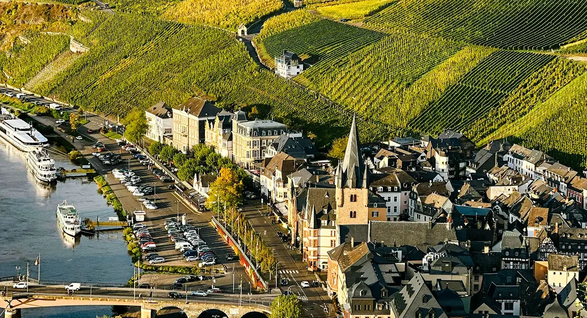Die malerische Doppelstadt Bernkastel-Kues, die am Ufer der Mosel liegt und von ausgedehnten, steilen Weinbergen umgeben ist.