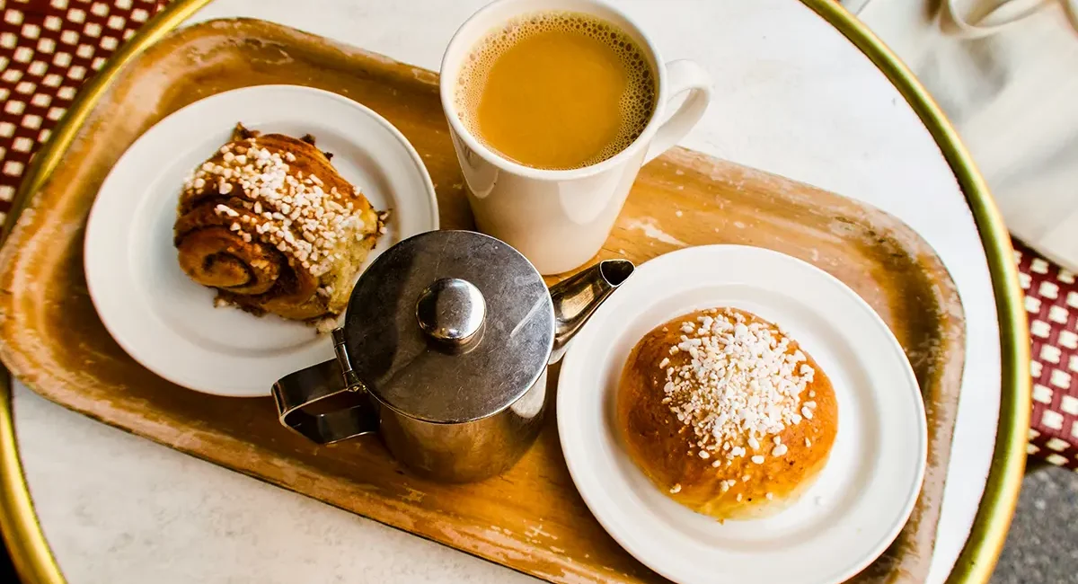Eine Tasse Kaffee mit einer Zimtschnecke und einem Zimtbrötchen in Finnland