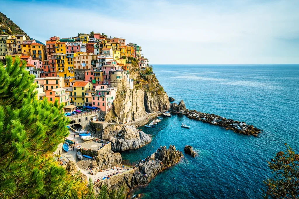 Das malerische Dorf Manarola in den Cinque Terre an der italienischen Riviera, dessen farbenfrohe Häuser sich eng an die steilen Felsklippen über dem tiefblauen Meer schmiegen.