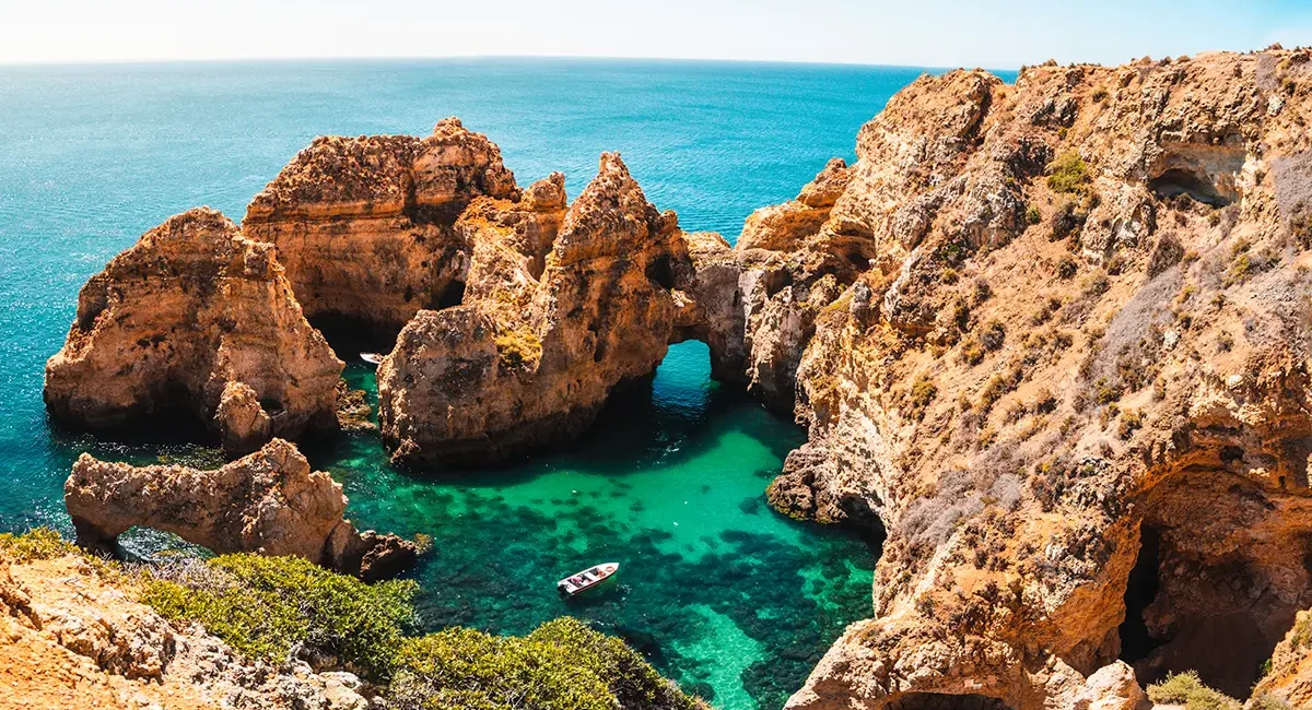 Eine beeindruckende Felsformation mit natürlichen Bögen und türkisfarbenem Wasser, gelegen an der Küste der Algarve in Portugal.