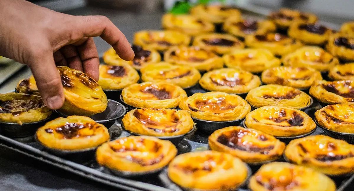 Die berühmten portugiesischen Blätterteigtörtchen Pastéis de Nata, die mit einer süßen Vanillepuddingfüllung gefüllt sind.