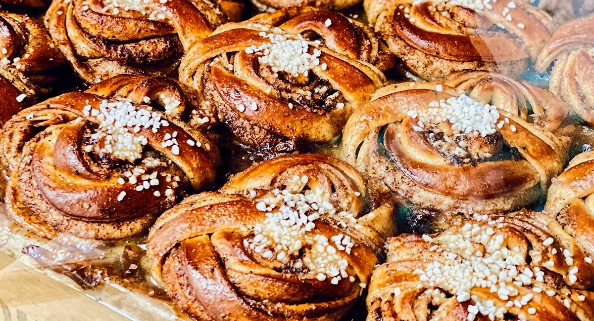 Hinter einer Verkaufstheke liegen einige frische schwedische Zimtschnecken.