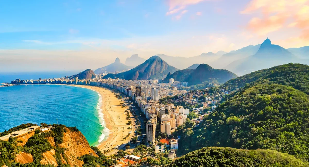 Die brasilianische Stadt Rio de Janeiro mit seinem berühmten Strand, dem Meer und dem markanten Bergland im Hintergrund.