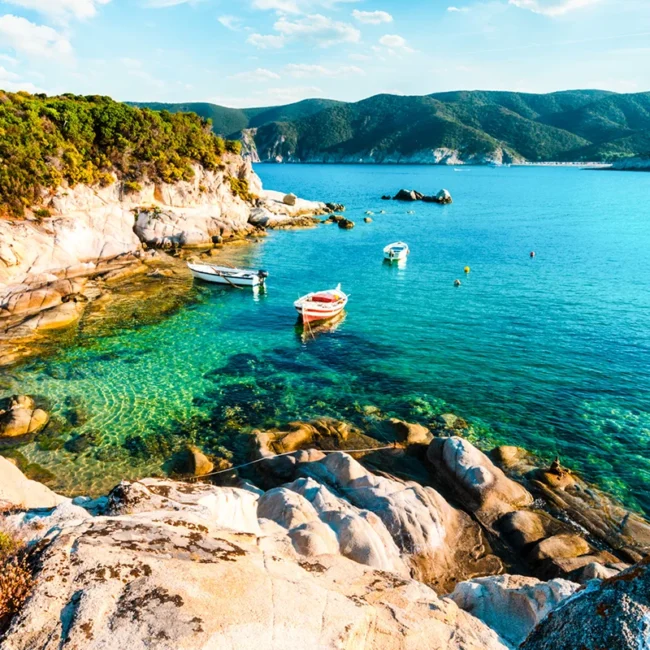 Die Küstenlandschaft mit kleinen Fischerbooten auf Chalkidiki in Griechenland.