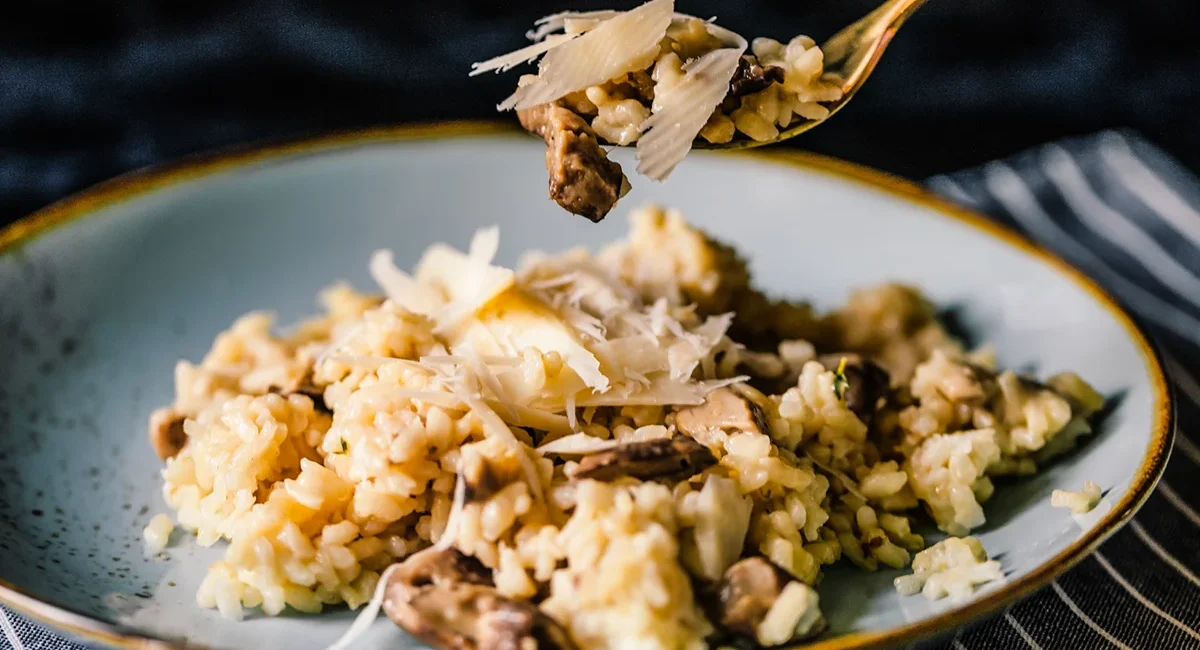 Ein Teller italienisches Risotto mit Pilzen und Parmesan im Piemont.