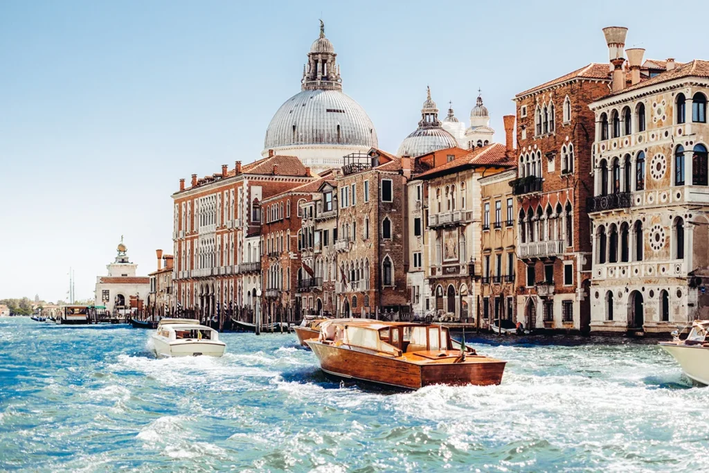 Der Canal Grande in Venedig mit Booten und der berühmten Kirche Santa Maria della Salute im Hintergrund,.