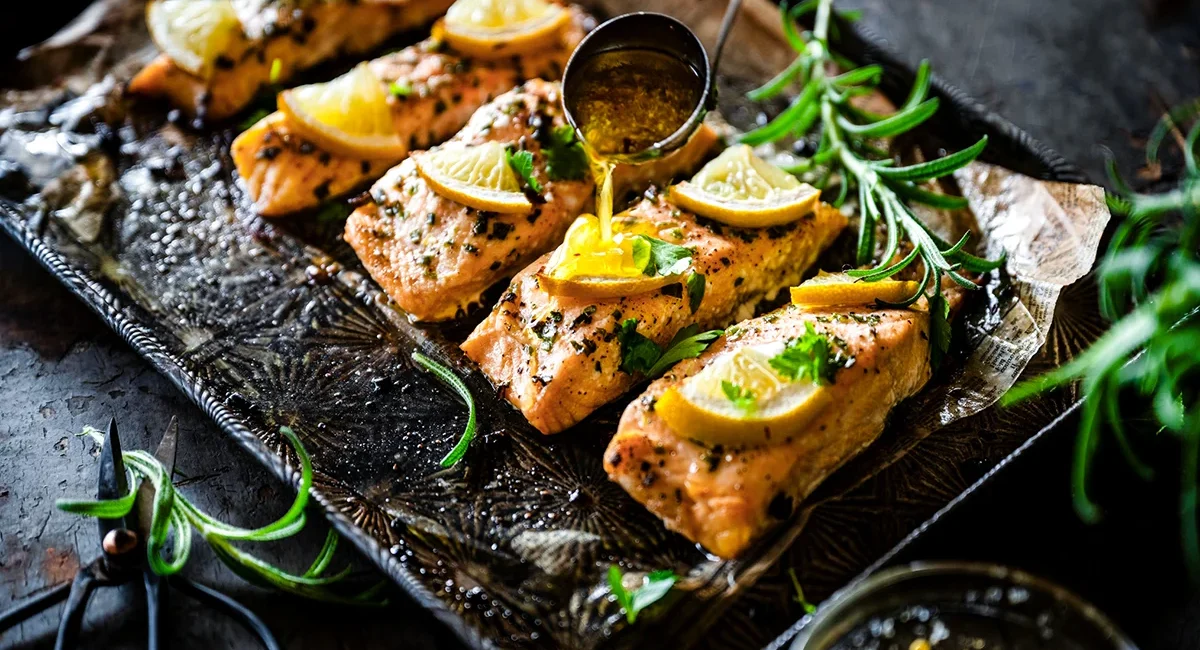 Mit Honig glasierte Lachsfilets, die auf einem Backblech zubereitet werden.