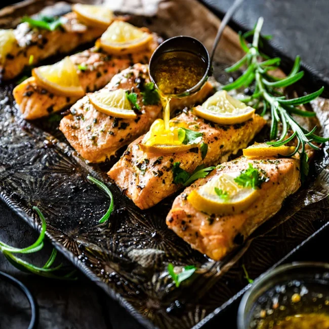 Mit Honig glasierte Lachsfilets, die auf einem Backblech zubereitet werden.