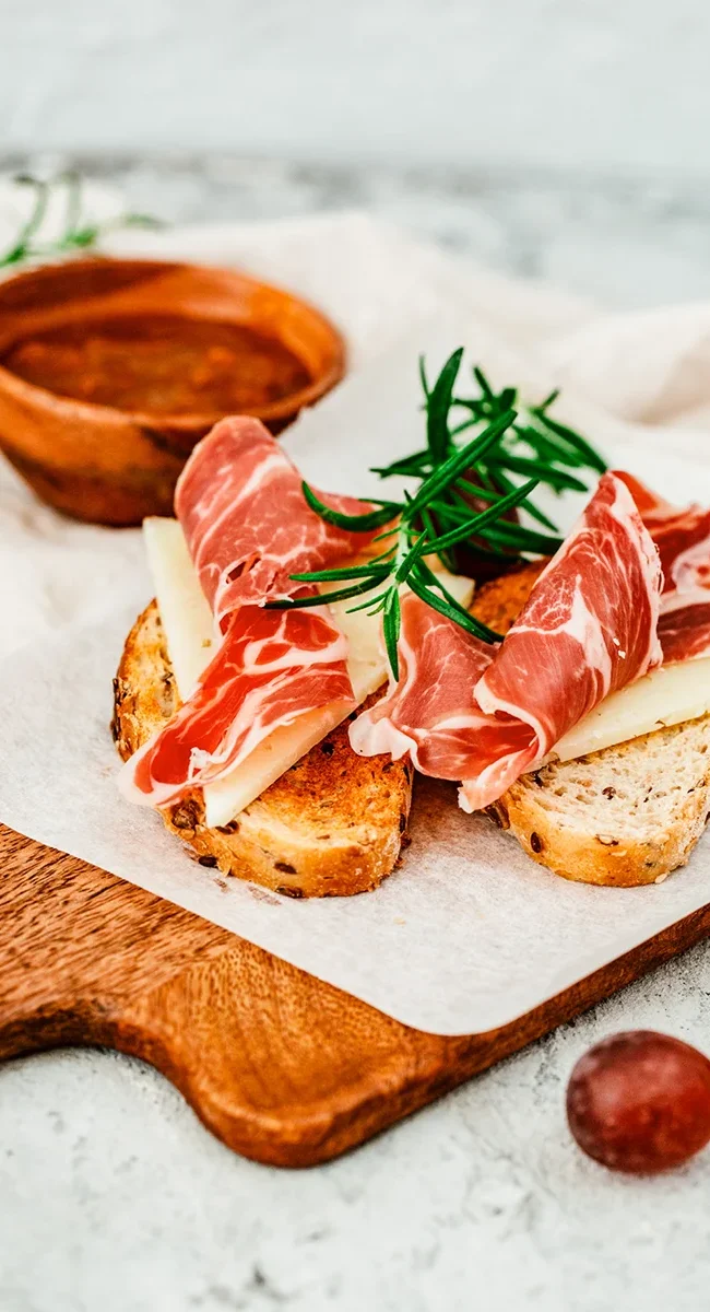 Ein Teller mit Tapas aus Andalusien mit dünn geschnittenem Schinken.