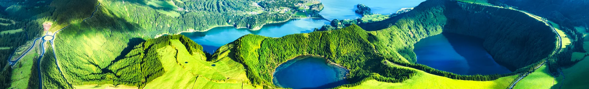 Panoramablick auf die Kraterseen von Sete Cidades auf der Azoreninsel São Miguel. Die beiden Seen liegen in einem großen Vulkankrater, umgeben von grünen Hügeln.