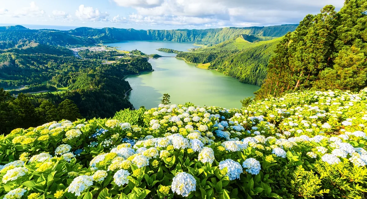 Blick vom Aussichtspunkt Vista do Rei auf die Kraterseen von Sete Cidades auf den Azoren. Die beiden Seen liegen in einer grünen Vulkanlandschaft.