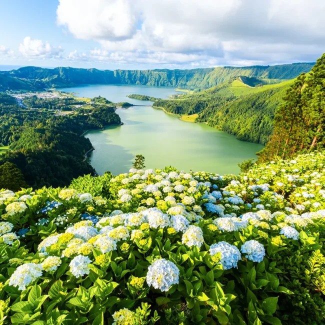 Blick vom Aussichtspunkt Vista do Rei auf die Kraterseen von Sete Cidades auf den Azoren. Die beiden Seen liegen in einer grünen Vulkanlandschaft.