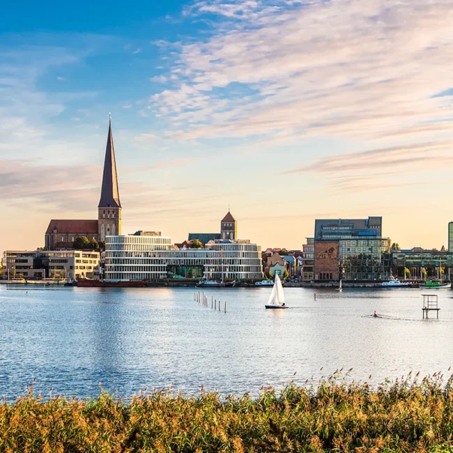 Blick auf Rostock mit Kirche, Wasser und der AIDA-Zentrale im Stadtbild