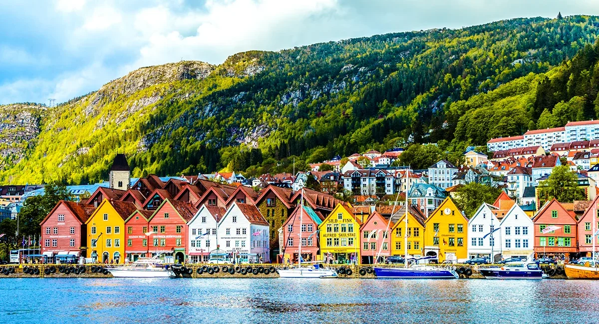 Blick auf die bunten Holzhäuser von Bryggen in Bergen, Norwegen. Die historischen Gebäude stehen dicht nebeneinander am Hafen.