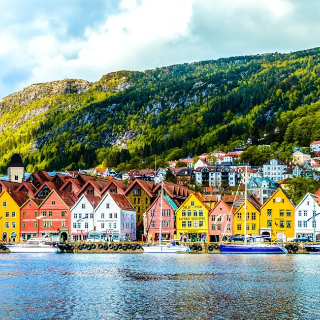 Blick auf die bunten Holzhäuser von Bryggen in Bergen, Norwegen. Die historischen Gebäude stehen dicht nebeneinander am Hafen.