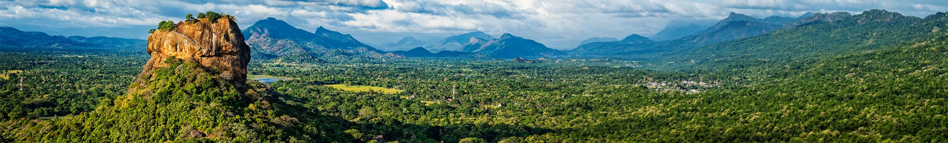 Der Sigiriya-Felsen in Sri Lanka ragt aus der grünen Landschaft heraus und bietet einen weiten Panoramablick über die Umgebung.