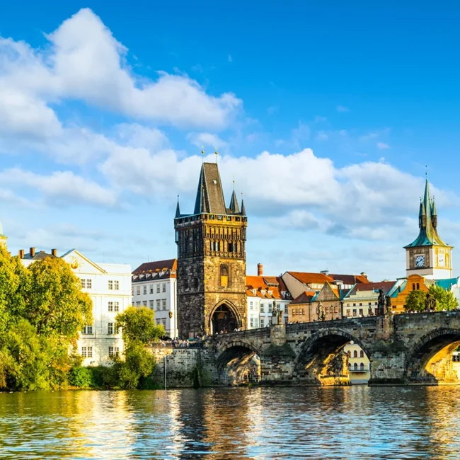 Blick von der Moldau auf die Karlsbrücke in Prag mit ihren steinernen Bögen über dem Wasser.