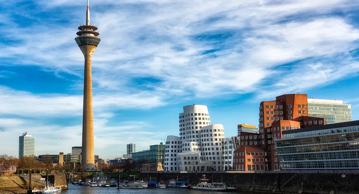 Blick auf den Rhein in Düsseldorf mit modernen Gebäuden und der Skyline am Ufer.