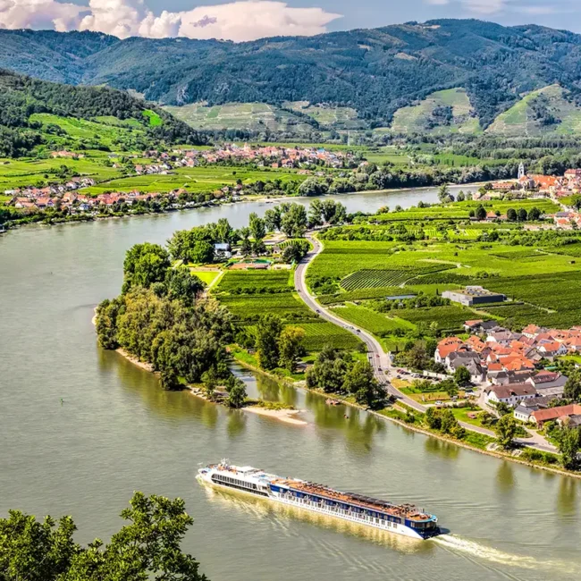 Blick auf die Donau in der Wachau mit einem Flusskreuzfahrtschiff auf dem Wasser.